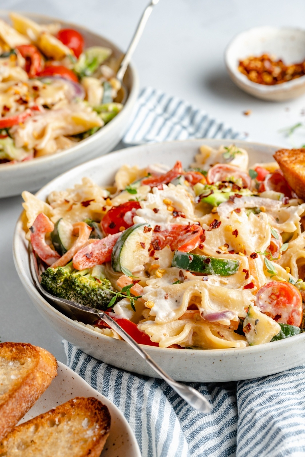 vegan pasta primavera in a bowl with a fork