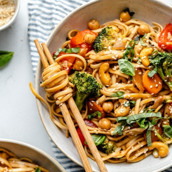 vegan stir fry noodles in a bowl with chopsticks