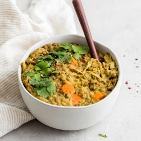 chicken lentil soup in a bowl with a wooden spoon