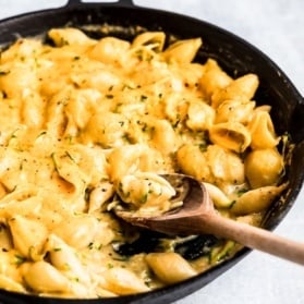 zucchini mac and cheese in a skillet with a spoon