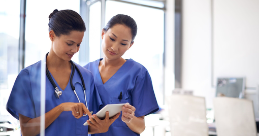 Shot of two female nurses using a tablet to review medical records