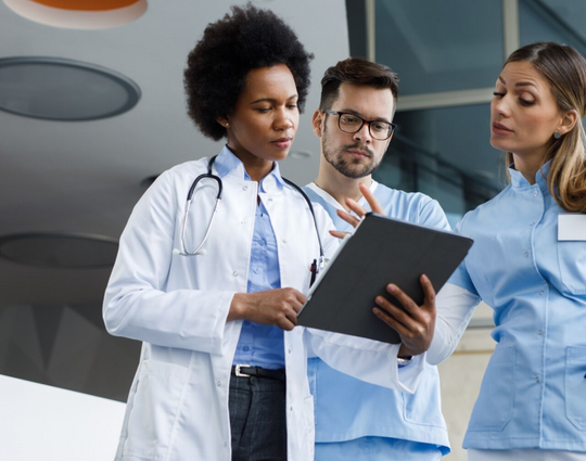 Group of medical practitioners analyzing x-rays on a digital tablet in a hospital