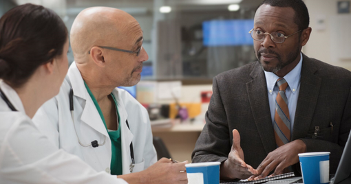 A hospital admin talking to two healthcare clinicians