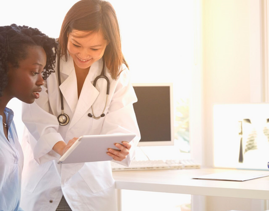 Doctor and woman reading digital tablet