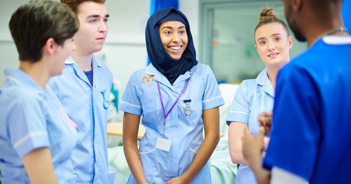 four young medical students chat to each other 