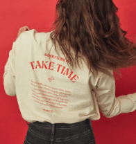 woman in a white long sleeve shirt with red writing